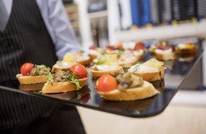 Servicekraft serviert Canapés auf einem Tablett